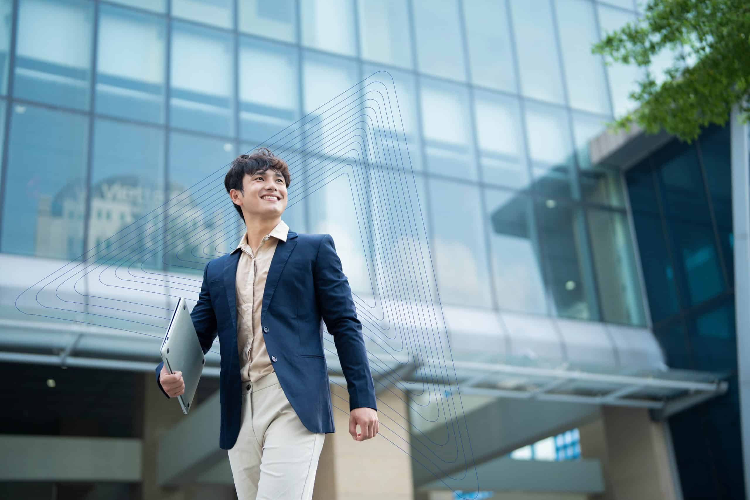 SEO Expert holding laptop outside modern office building